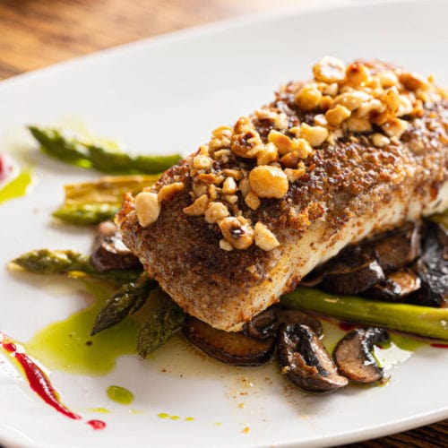 hazelnut-crusted halibut with asparagus, mushrooms, and sauce drizzle