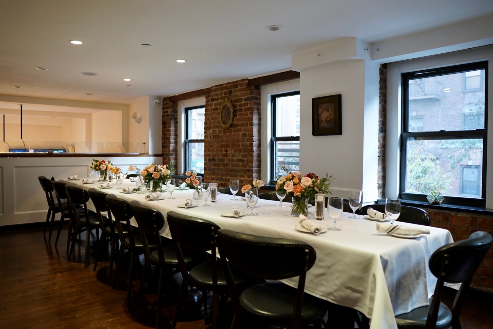 Elegant long table set for dining in brick-walled room