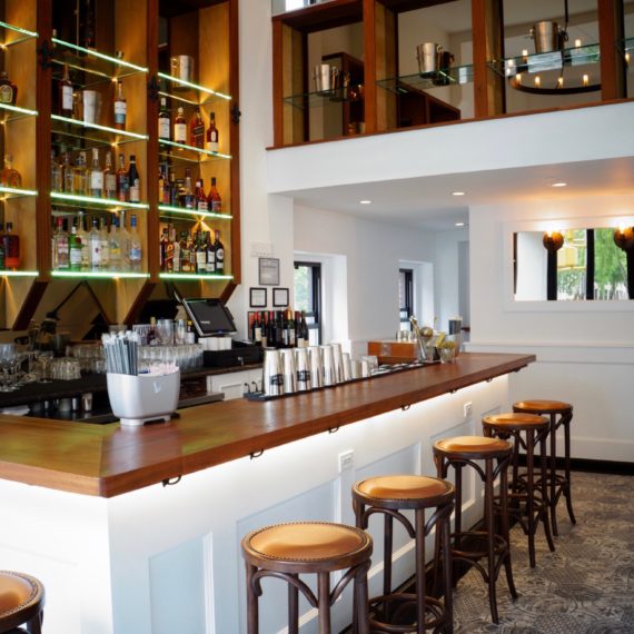 Bright, modern bar with backlit shelves and bar seating"