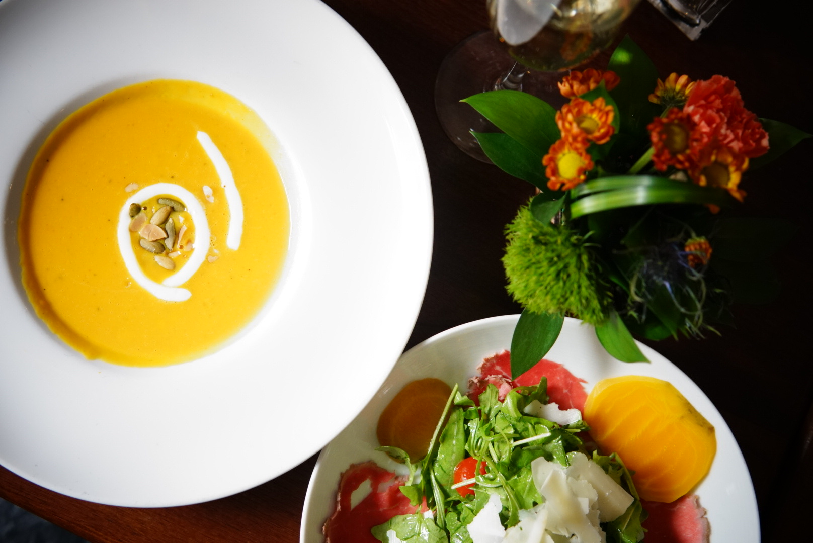 Butternut squash soup with cream swirl and salad with arugula, beets, and parmesan shavings