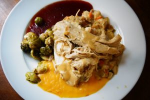 Thanksgiving plate with Roast turkey with stuffing, Brussels sprouts, cranberry sauce, and sweet potato purée