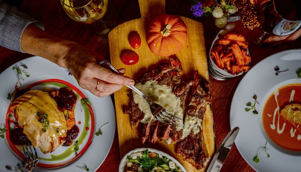 Thanksgiving meal spread with steak, turkey, soup, fries and win