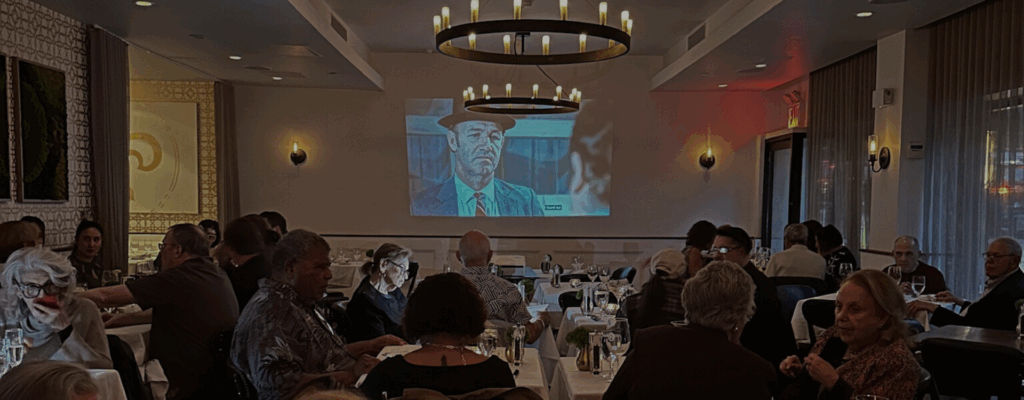 Dining room filled with diners while watching a movie on a pull down projector