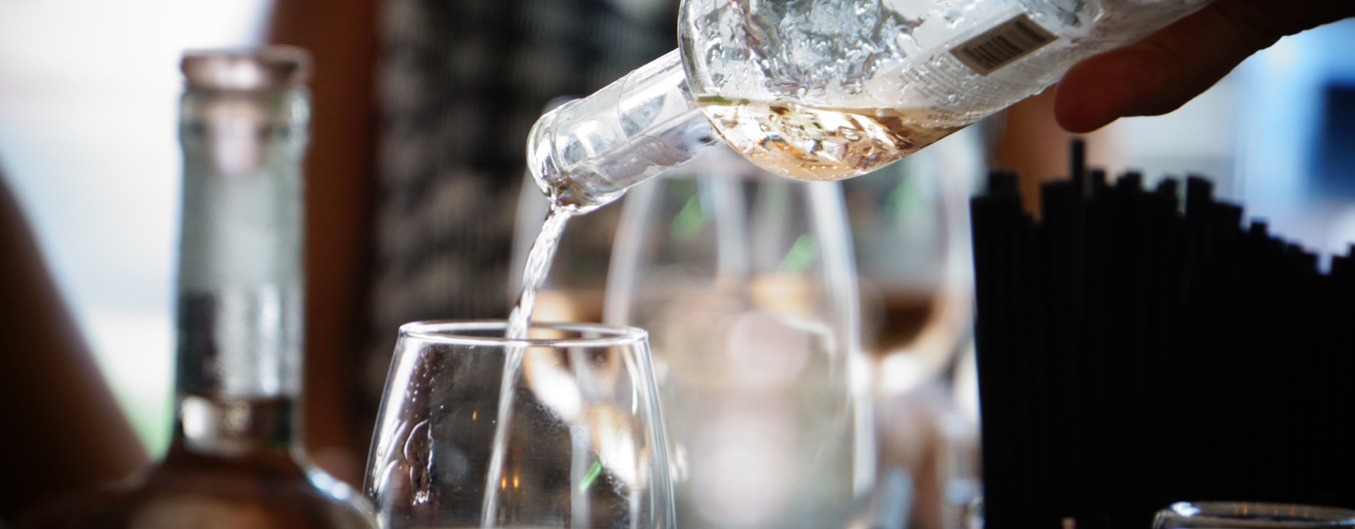 zoomed in photo of white wine being poured into a glass