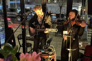guitarist and violist singing vocals into microphones